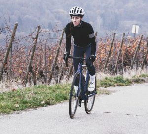 Young woman riding a bike in wineyards