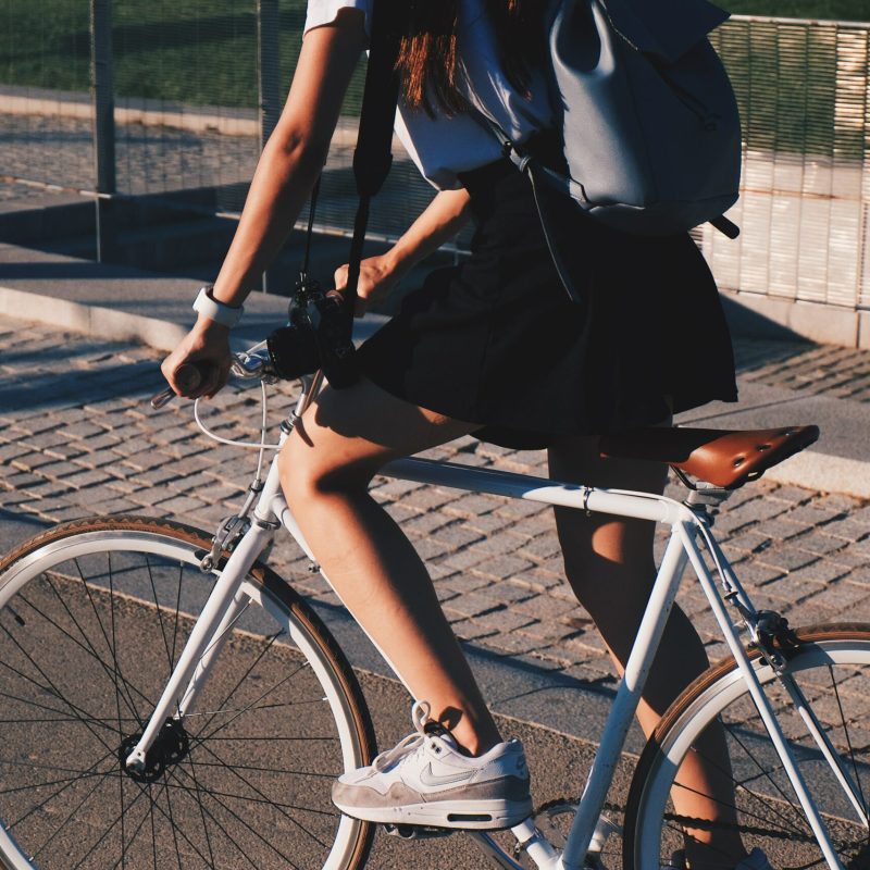 Legs of a young woman riding a bike in the city